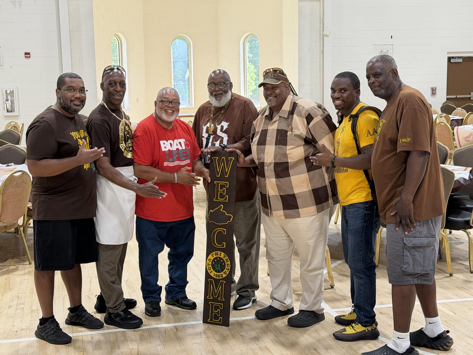 Brothers of Zeta Omega with the chapter welcome sign at the Crab Feast