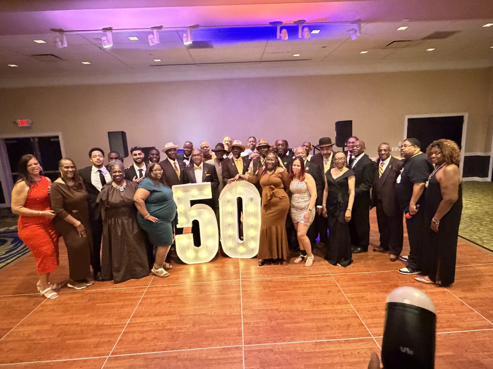 Chapter family gathered around the lighted 50 at an anniversary gala