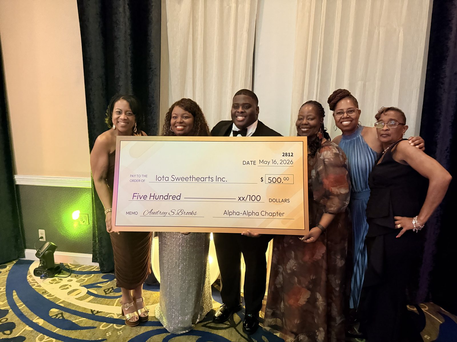 A scholarship check presentation at a formal gala