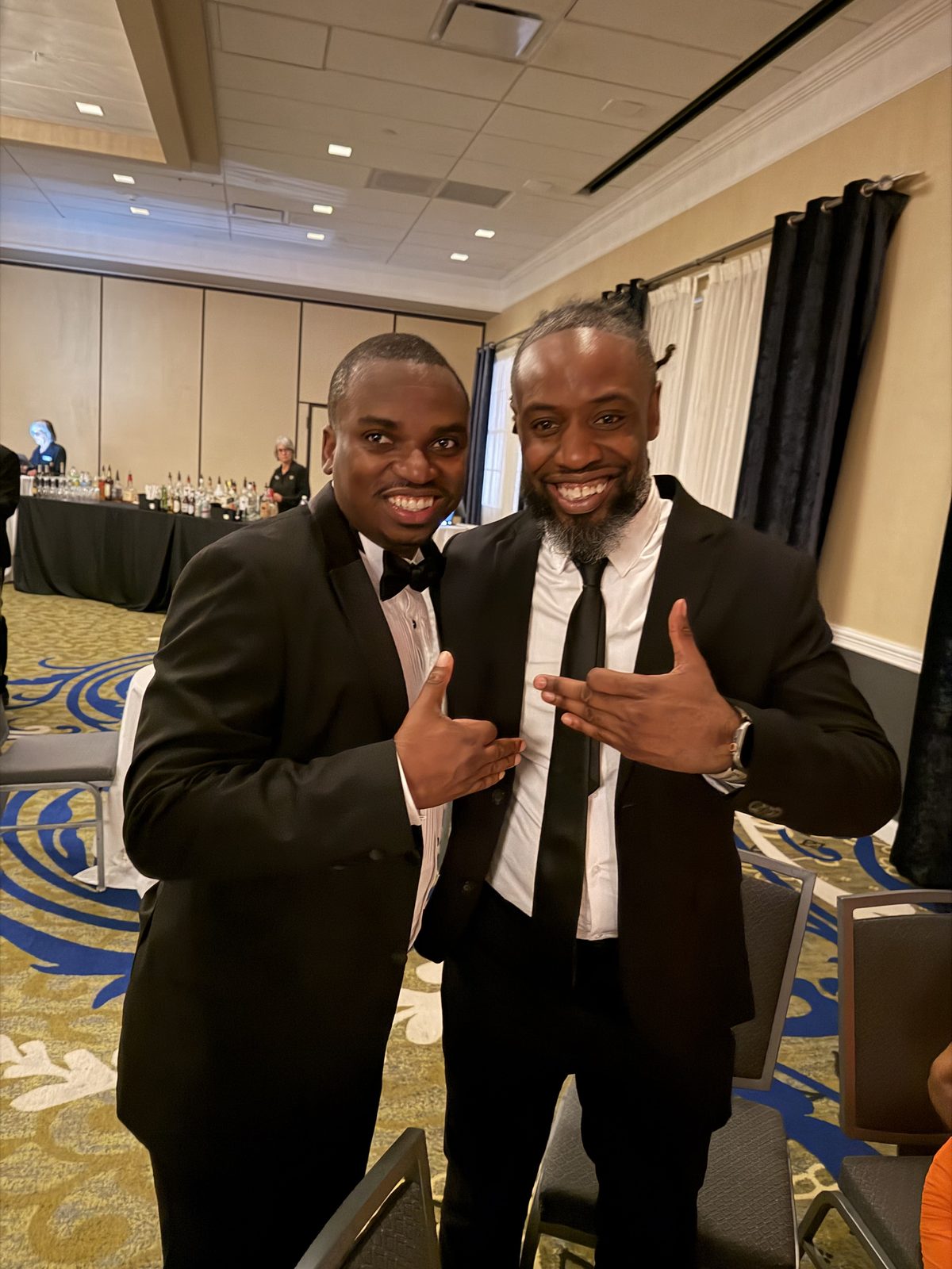 Two brothers in tuxedos at a formal event